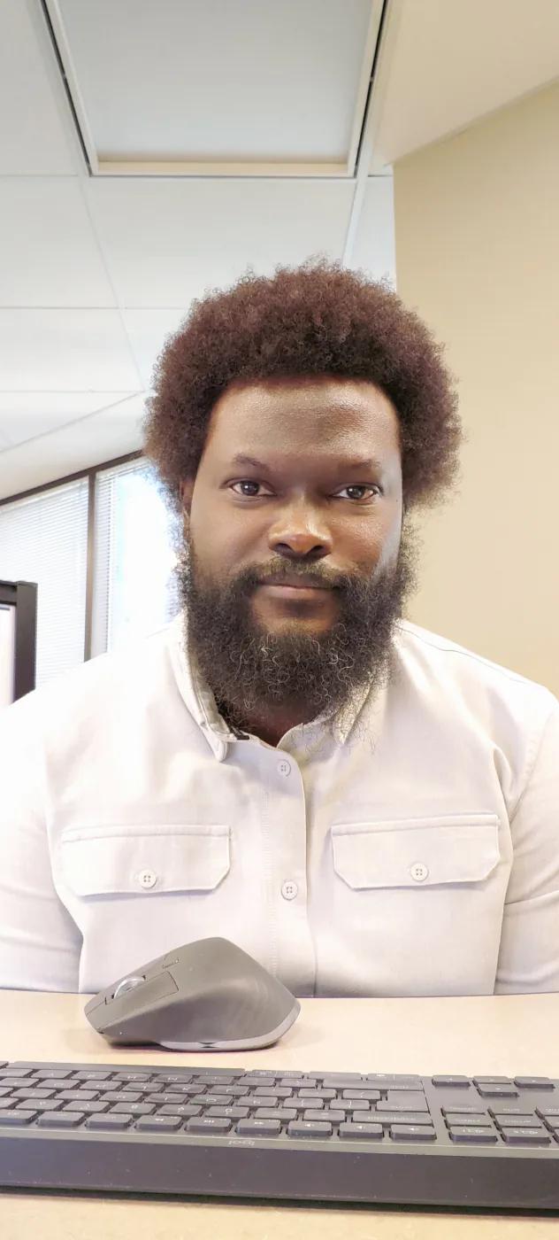 Dotun smiling at his desk